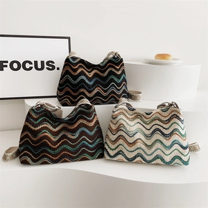 Three wave-patterned knit shoulder bags in black brown and cream on a white podium