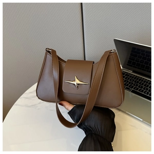 Dettaglio di una borsa baguette in pelle marrone con fibbia dorata a forma di stella