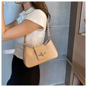 Dettaglio della borsa baguette color albicocca con fibbia a stella e texture in pelle chic