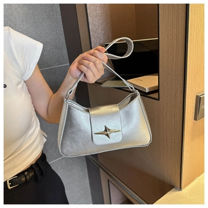 Dettaglio borsa baguette argento metallizzato con fibbia in metallo a forma di stella