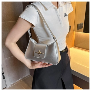 Dettaglio della borsa hobo argento metallizzato con fibbia a stella dorata e patta