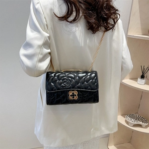 Black quilted camellia chain bag with gold clover lock on a stylish shoulder strap