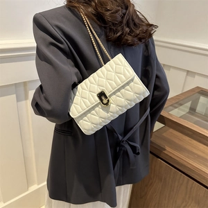 Classic white quilted crossbody bag with gold chain strap shown on a female model