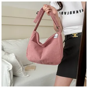 Pink corduroy hobo bag featuring adjustable strap and cute cartoon cloud pendant
