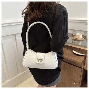 Détail du sac à main blanc en cuir PU avec boucle nœud doré porté par un modèle