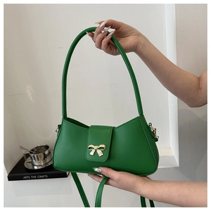 Détail du sac à bandoulière en similicuir vert avec boucle décorative en métal doré
