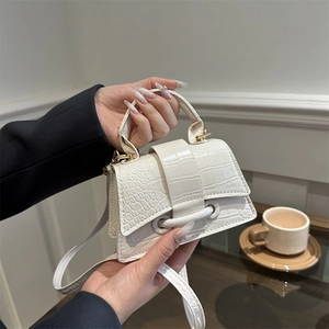 White croc-effect mini handbag with top handle and detachable strap in a lifestyle setting
