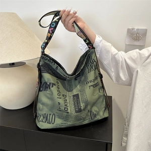 Green canvas tote bag with retro newspaper print and colorful letter straps