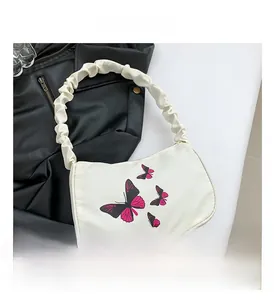 Detail of white butterfly print shoulder bag with ruched handle and zip closure