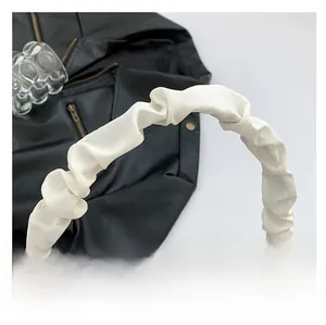 Detailed macro view of the cream white PU leather bag with stylish ruched handle