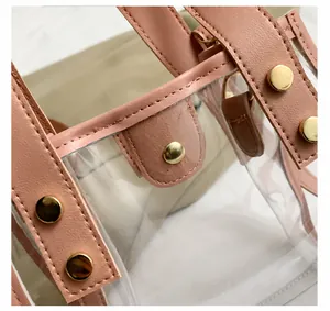 Detail shot of clear PVC handbag with pink leather trim and gold rivet hardware
