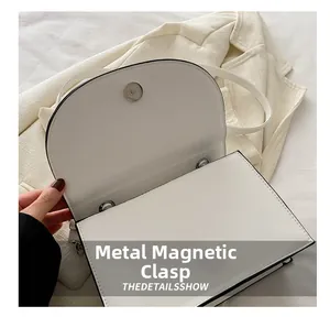 Detalle del bolso de cuero blanco con cierre de botón magnético metálico de calidad