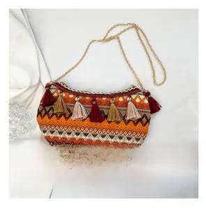 Close-up of bohemian woven crossbody bag with colorful patterns and fringe details