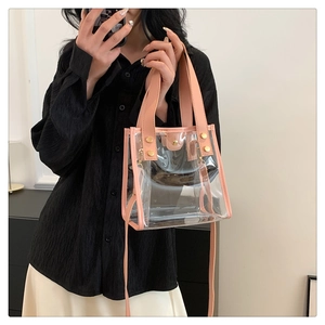 Detail of transparent PVC beach bag with pink leather trim and gold rivet reinforcement