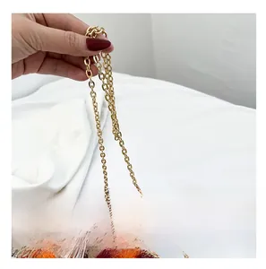 Detailed view of the gold metal chain strap on a bohemian ethnic style crescent bag
