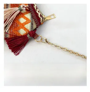 Close-up of woven ethnic bag featuring orange diamond texture and premium gold hardware