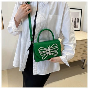 Detalle del bolso de cuero verde esmeralda con motivo de mariposa de diamantes plateados