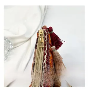 Detail of ethnic woven shoulder bag featuring golden zipper and multicolor tassels