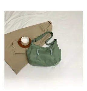 Top view of a green nylon tote bag with utility pockets and adjustable shoulder strap