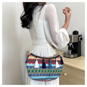 Close-up of ethnic style woven shoulder bag with colorful geometric patterns and tassels