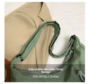 Detail view of grass green nylon bag with adjustable shoulder strap and woven zipper pull
