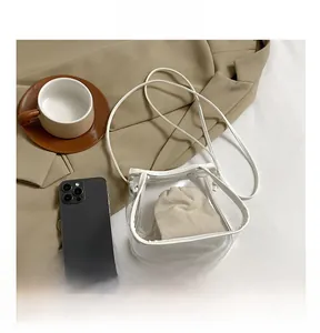 Detail of transparent PVC crossbody bag with white leather trim and beige drawstring inner pouch
