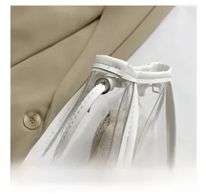 Detail showing silver metal eyelets and white faux leather trim on a clear PVC jelly bag