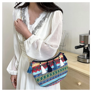 Lifestyle shot of ethnic crossbody bag with bohemian wave patterns and colorful tassels