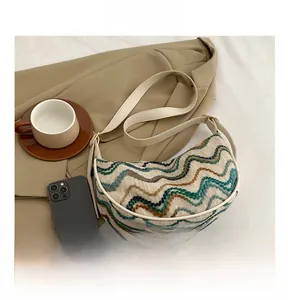 Detail of colorful wavy knit pattern on a crescent bag styled with a beige blazer
