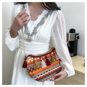 Detail of bohemian moon bag featuring colorful woven patterns and vibrant layered tassels