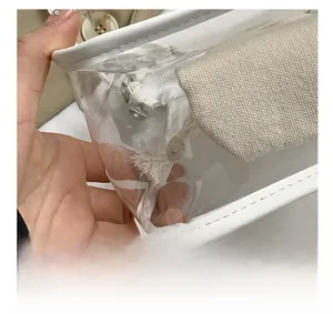 Detail showing precise stitching on white leather trim of the transparent PVC jelly bag