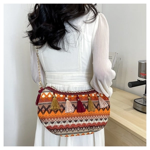 Detail of bohemian woven half-moon bag featuring colorful wave patterns and long tassels