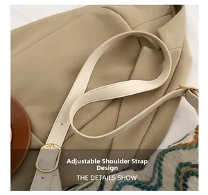 Detail of adjustable cream leather shoulder strap with golden buckle and fine stitching