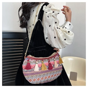 Detail of colorful woven shoulder bag with bohemian tassels and metallic chain strap