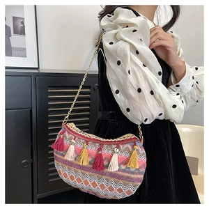 Detail of bohemian crescent bag featuring colorful woven patterns and vibrant long tassels