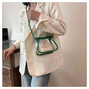 Detailed shot of mini transparent PVC crossbody bag with green trim and drawstring liner