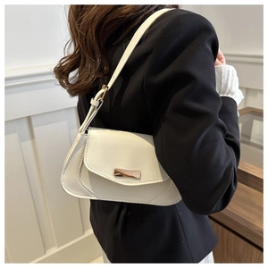 Detail view of a white minimalist baguette shoulder bag with metallic buckle and adjustable strap