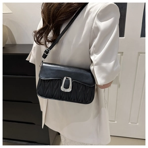 Vue détaillée du sac bandoulière noir avec matelassage plissé et boucle argentée