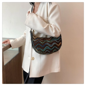 Detail showing retro wavy pattern stitching and dark brown texture on a half-moon bag