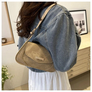 Detail of khaki geometric baguette bag with metallic buckle and adjustable shoulder strap