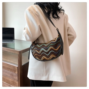 Detail of bohemian striped crescent bag with vibrant embroidery and leather strap