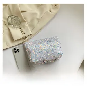 Detail of iridescent sequin makeup bag on a beige blazer background with lifestyle decor