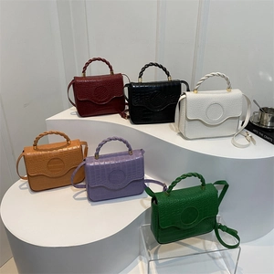 Chic croc-embossed square crossbody bags in multiple colors on a tiered display stand
