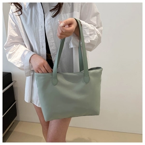 Detail view of reinforced teardrop stitching on light green lightweight tote bag
