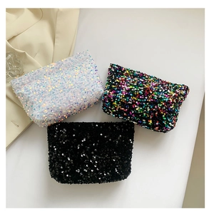 Detailed view of sequin clutch bags in pearl white, rainbow black, and classic black