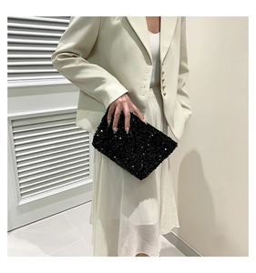 Detailed view of the sparkling black sequin texture on a rectangular fashion clutch bag