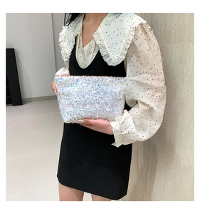Close-up of a white iridescent sequin clutch bag showing a shimmering rainbow effect