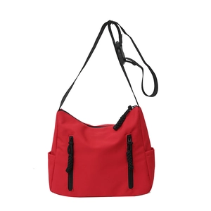 Minimalist red nylon tote bag with black vertical zippers and adjustable straps