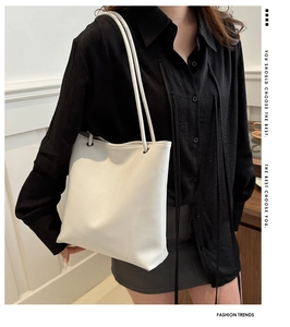 Close-up of minimalist white tote bag with marketing text and stylish model presentation