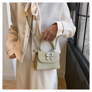 Gros plan d'un sac bandoulière vert menthe avec boucle nœud sur un mannequin élégant
